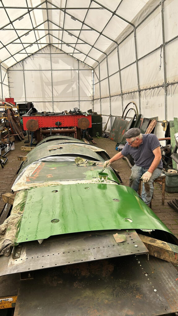 Dave Giddins paints firebox cladding in readiness for fitting on 8th June. This is green undercoat, rather than any attempt to repaint 7802 into SR Malachite Green….! Photo: Martin Creese