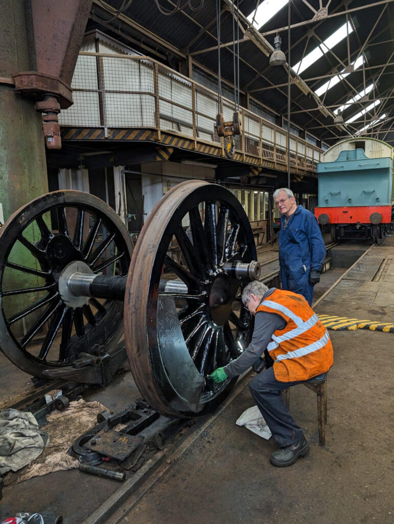 On 14th June, Jane Preece finish paints the trailing coupled wheelset prior to axlebox refitting under the watchful eye of Andrew Boucher. Photo: Adrian Hassell